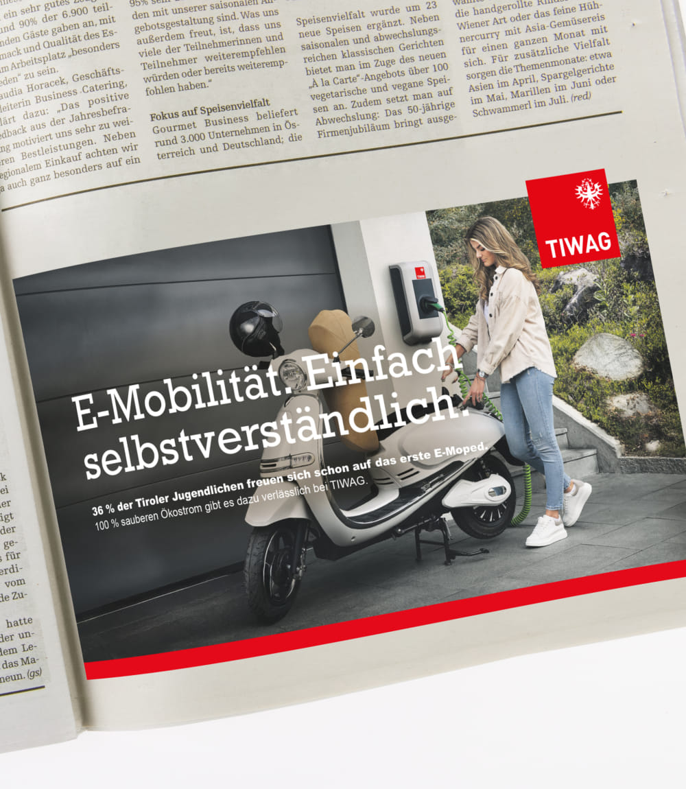 TIWAG-Anzeige in einer Zeitschrift mit junge Frau, die E-Roller auflädt und dem Slogan E-Mobilität. Einfach selbstverständlich. mit Statistik zu Tiroler Jugendlichen.